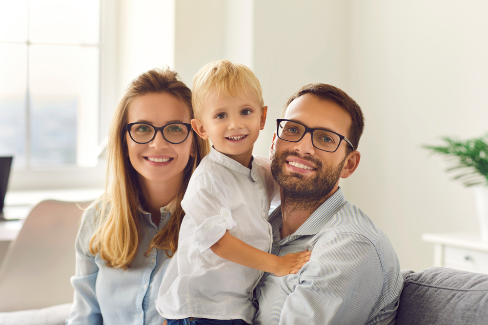 Portrait,Of,Happy,Young,Smiling,Family,Sitting,,Holding,Little,Son